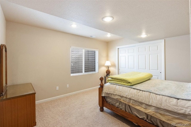 bedroom with light carpet, a closet, and a textured ceiling