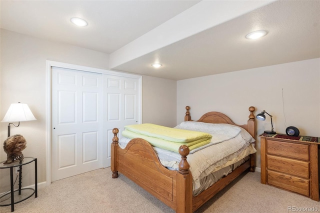 bedroom featuring light colored carpet and a closet