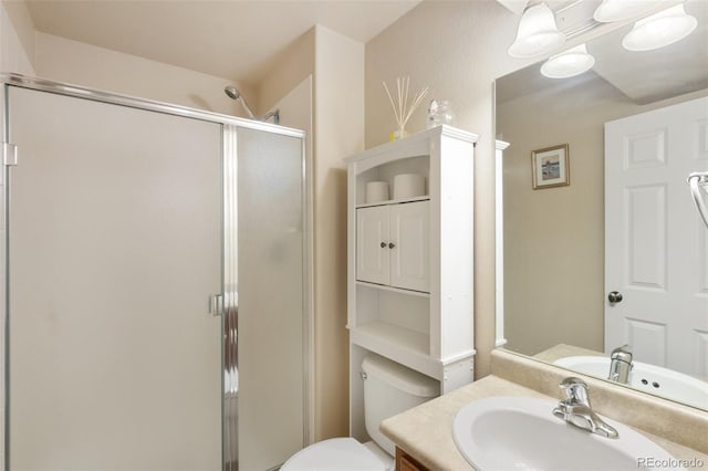 bathroom featuring vanity, toilet, and a shower with shower door