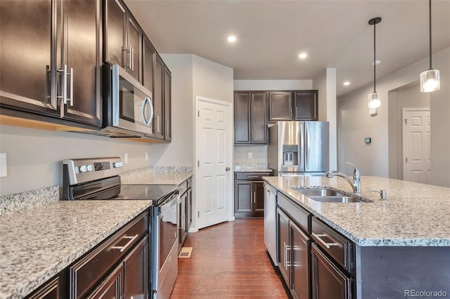 15955 E Otero Cir, Centennial, CO 80112 - kitchen featuring stainless steel appliances, dark wood-style flooring, dark brown cabinetry, an island with sink, and light stone counters