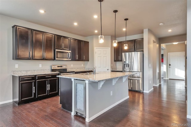 15955 E Otero Cir, Centennial, CO 80112 - kitchen with appliances with stainless steel finishes, dark wood-style floors, light stone counters, dark brown cabinetry, and recessed lighting