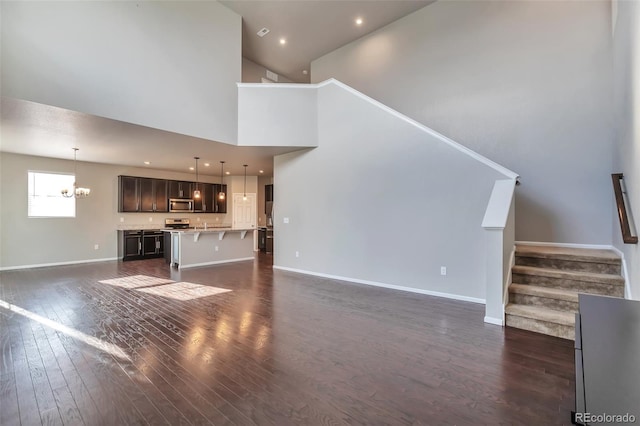15955 E Otero Cir, Centennial, CO 80112 - unfurnished living room featuring a chandelier, dark wood-style floors, stairway, a towering ceiling, and recessed lighting
