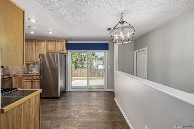 kitchen with backsplash, stainless steel appliances, a notable chandelier, dark wood-type flooring, and pendant lighting