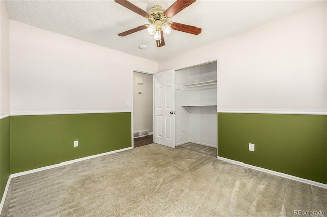 unfurnished bedroom featuring a closet, a textured ceiling, ceiling fan, and carpet flooring