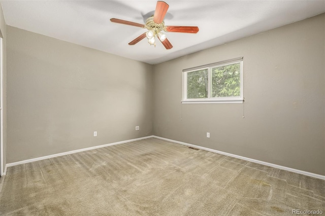 carpeted spare room featuring ceiling fan