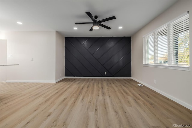 empty room with ceiling fan and light wood-type flooring