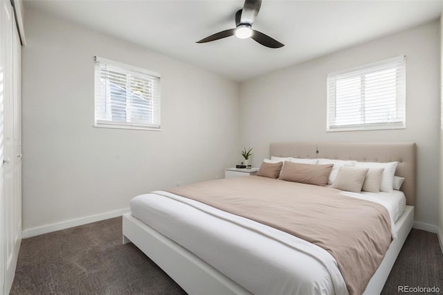 bedroom featuring ceiling fan, a closet, multiple windows, and dark colored carpet