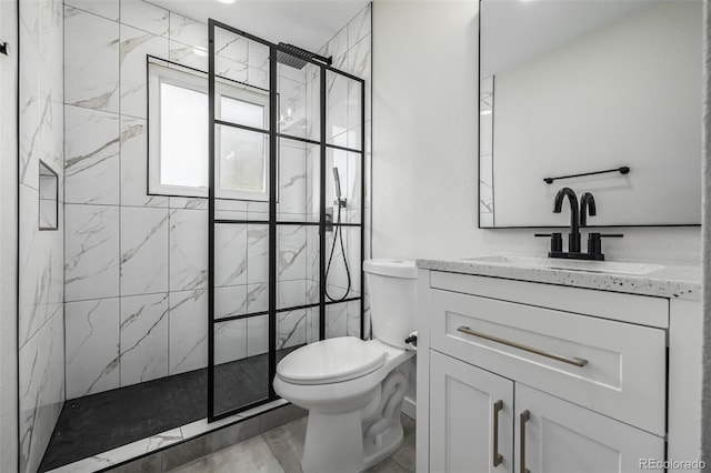 bathroom with toilet, a tile shower, and vanity