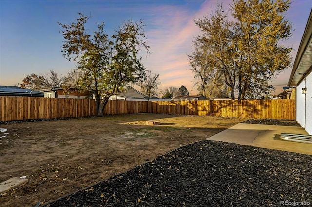 yard at dusk with a patio area