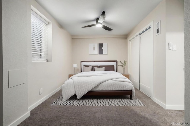 carpeted bedroom with ceiling fan and a closet