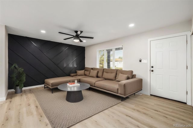 living room featuring light wood-type flooring and ceiling fan