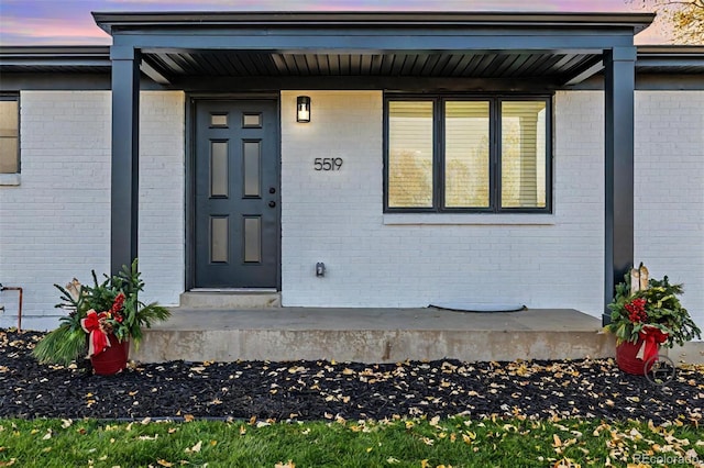 exterior entry at dusk featuring a porch