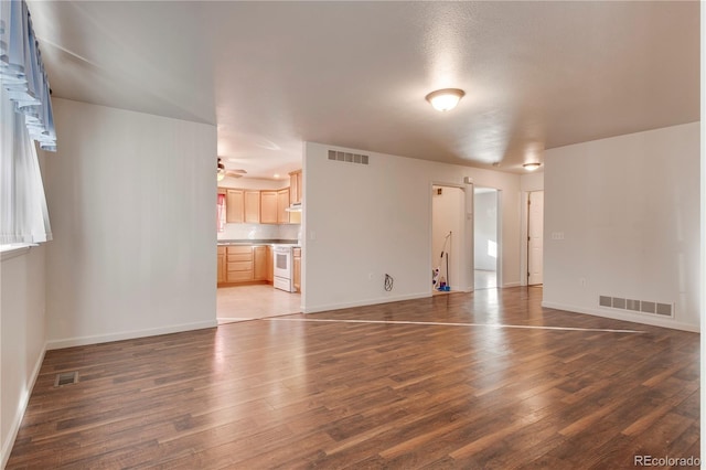 empty room with dark hardwood / wood-style floors and ceiling fan