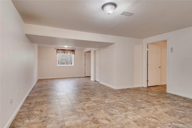 unfurnished room with a textured ceiling