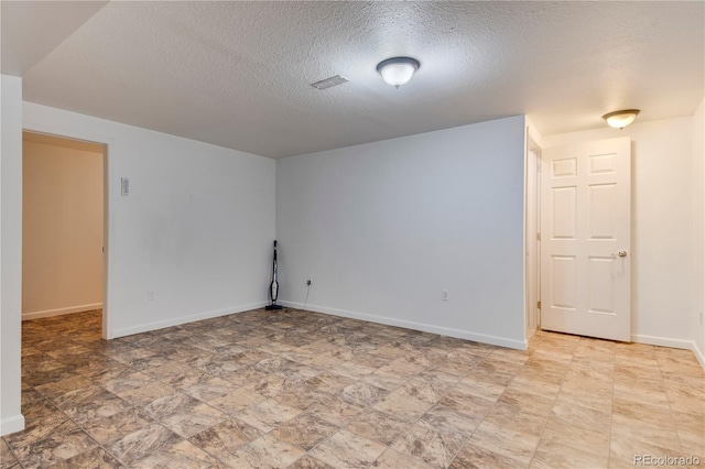 unfurnished room featuring a textured ceiling