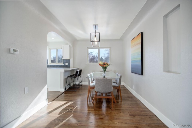 dining area with dark hardwood / wood-style floors and an inviting chandelier