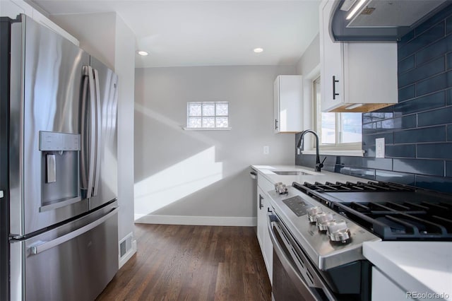 kitchen featuring exhaust hood, sink, dark hardwood / wood-style floors, white cabinetry, and stainless steel appliances