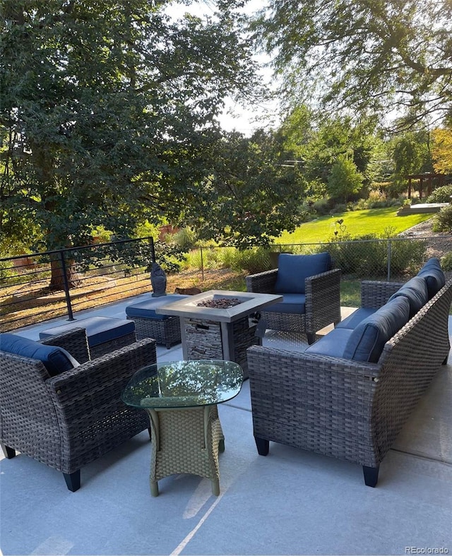 view of patio with an outdoor living space with a fire pit