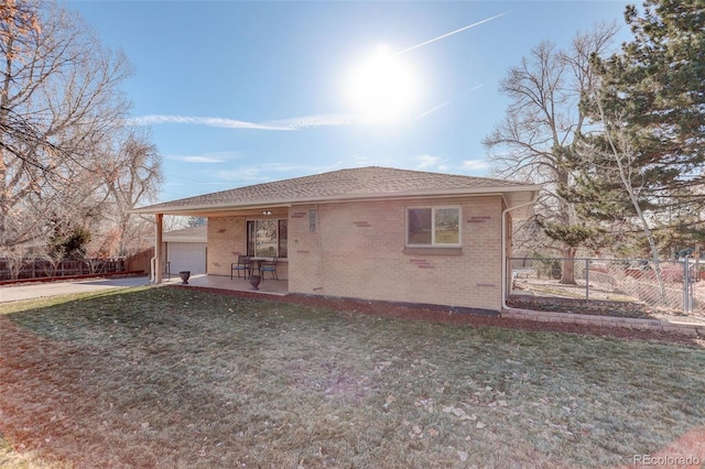 rear view of house with a lawn and a garage