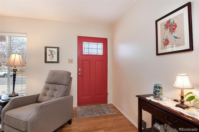 foyer entrance with plenty of natural light, baseboards, and light wood-type flooring