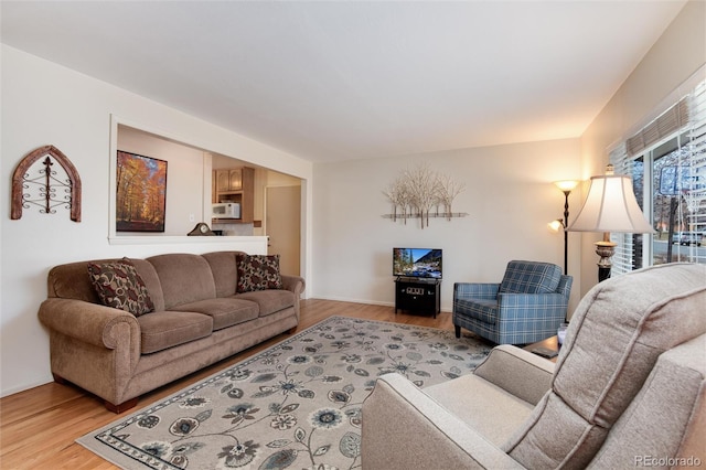 living area featuring light wood-style flooring and baseboards