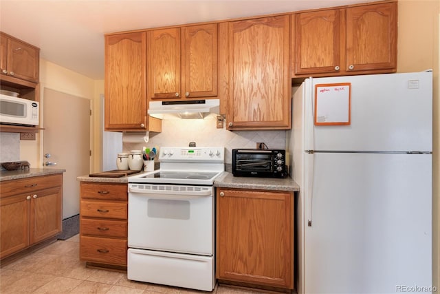 kitchen with white appliances, a toaster, light countertops, under cabinet range hood, and tasteful backsplash