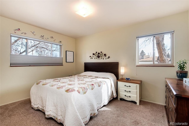 bedroom featuring multiple windows, light colored carpet, and baseboards