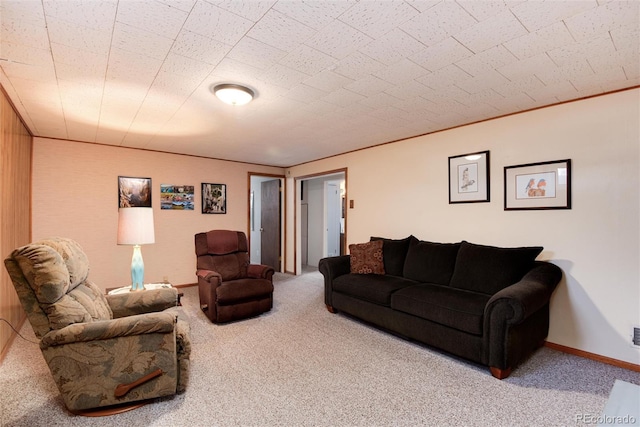 carpeted living area featuring baseboards and ornamental molding