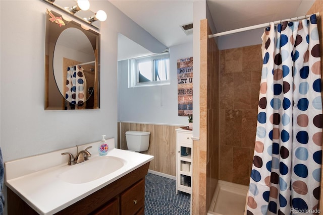 full bathroom with a wainscoted wall, a stall shower, vanity, and wood walls