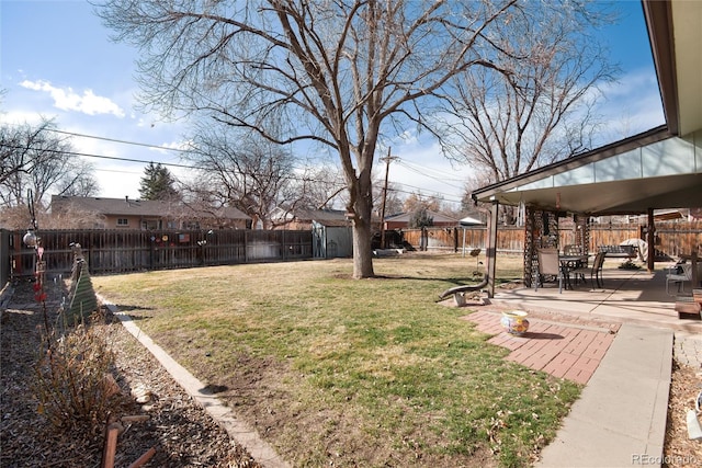 view of yard featuring an outbuilding, a fenced backyard, and a patio area