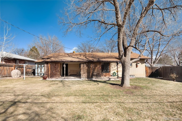 rear view of property featuring a patio, a yard, a fenced backyard, and brick siding