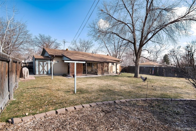 back of house featuring brick siding, a yard, a patio, and a fenced backyard