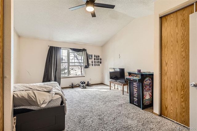 bedroom with baseboards, carpet, vaulted ceiling, a textured ceiling, and a ceiling fan