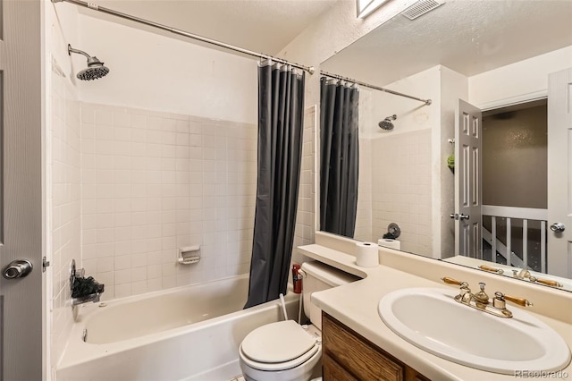 bathroom featuring vanity, visible vents, shower / bath combo with shower curtain, a textured ceiling, and toilet