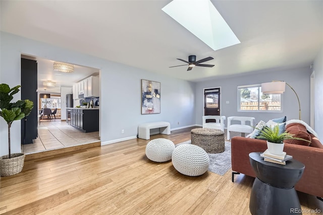 1280 S Quitman St, Denver, CO 80219 - living room featuring light wood-style flooring, a skylight, and ceiling fan