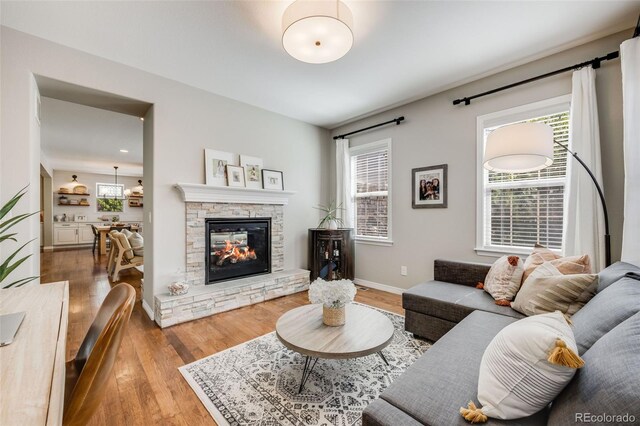 10590 Soulmark Way, Highlands Ranch, CO 80126 - living room featuring wood finished floors, plenty of natural light, and a fireplace