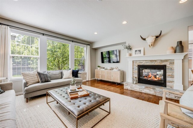 10590 Soulmark Way, Highlands Ranch, CO 80126 - living room featuring plenty of natural light, wood finished floors, recessed lighting, a fireplace, and baseboards