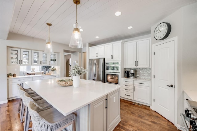 10590 Soulmark Way, Highlands Ranch, CO 80126 - kitchen featuring appliances with stainless steel finishes, white cabinets, a kitchen island, glass insert cabinets, and backsplash