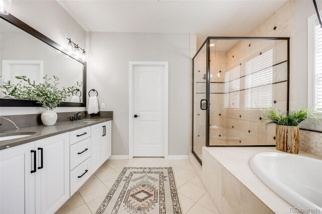 10590 Soulmark Way, Highlands Ranch, CO 80126 - bathroom featuring a bath, tile patterned flooring, a shower stall, double vanity, and baseboards