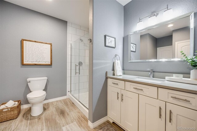 10590 Soulmark Way, Highlands Ranch, CO 80126 - bathroom with wood finished floors, a stall shower, toilet, vanity, and baseboards