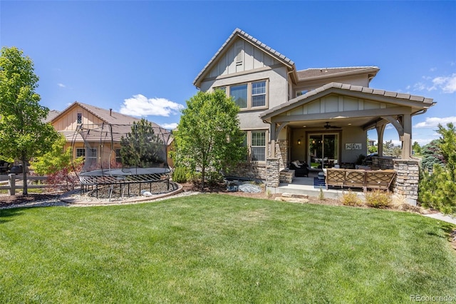 10590 Soulmark Way, Highlands Ranch, CO 80126 - back of house featuring an outdoor living space, a ceiling fan, stucco siding, a trampoline, and stone siding
