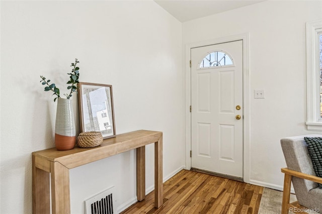 foyer featuring visible vents, light wood-style flooring, and baseboards