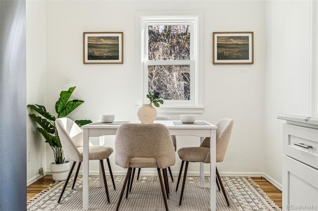 dining space featuring light wood-style floors and baseboards