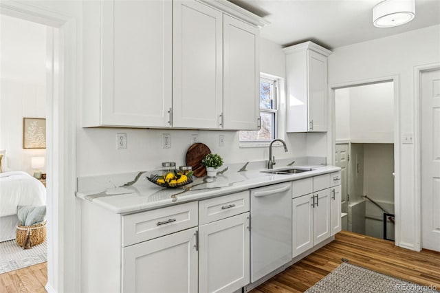 kitchen featuring white cabinetry, dishwasher, a sink, and wood finished floors