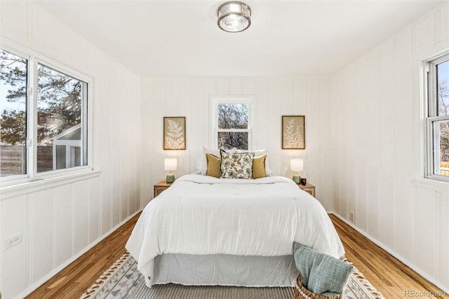 bedroom with light wood-type flooring and multiple windows