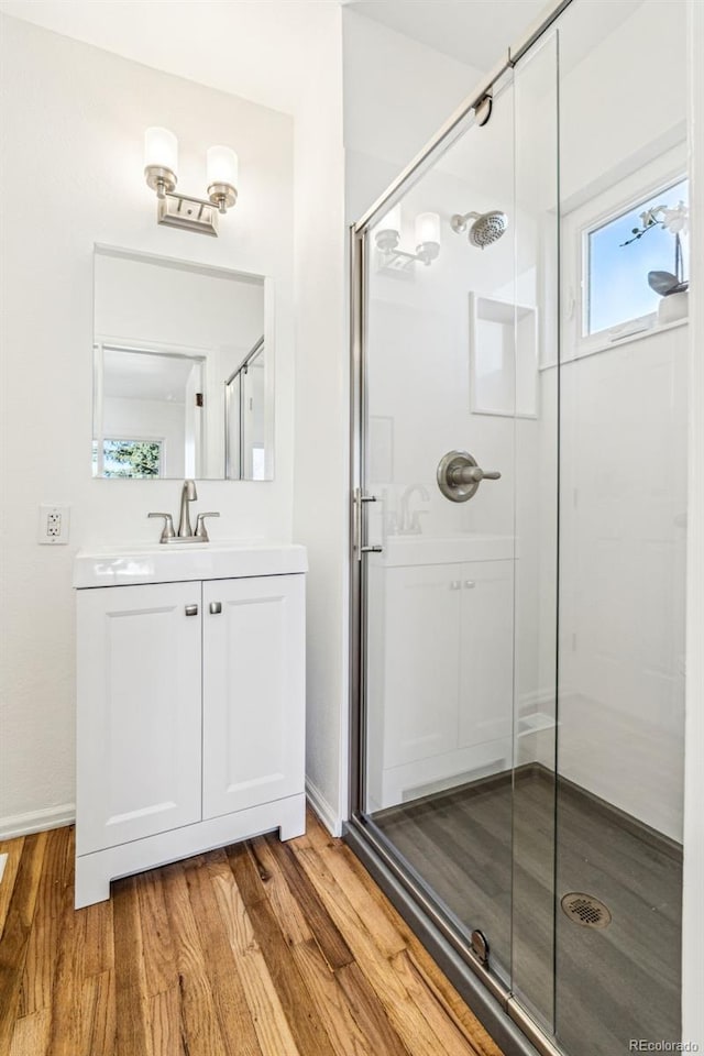 bathroom with a shower stall, vanity, and wood finished floors