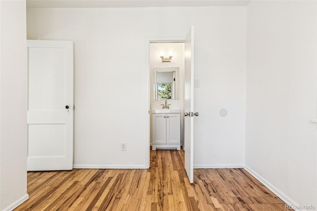 unfurnished bedroom featuring light wood finished floors and baseboards