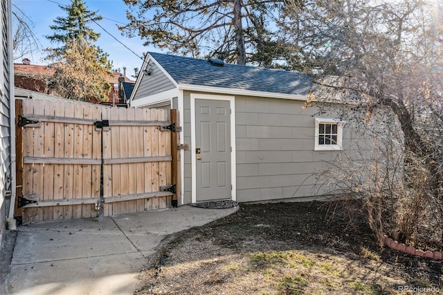 view of outbuilding featuring an outbuilding, a gate, and fence