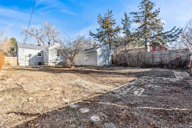 view of yard featuring a fenced backyard, a storage unit, and an outdoor structure