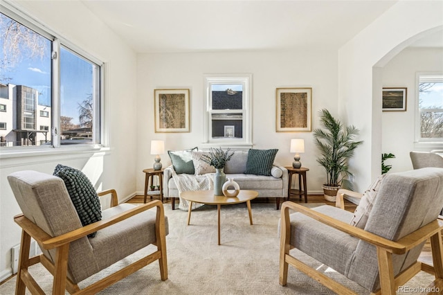 sitting room featuring arched walkways and baseboards